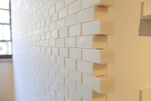 Photo of bars of cream coloured soap, stacked like bricks. 