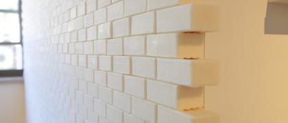 Photo of bars of cream coloured soap, stacked like bricks. 