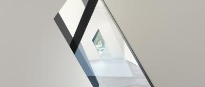 Sarah Oppenheimer, "33-D," 2014 Photo of tilted door frames, layered with glazing, and a diamond shaped window at the rear wall.